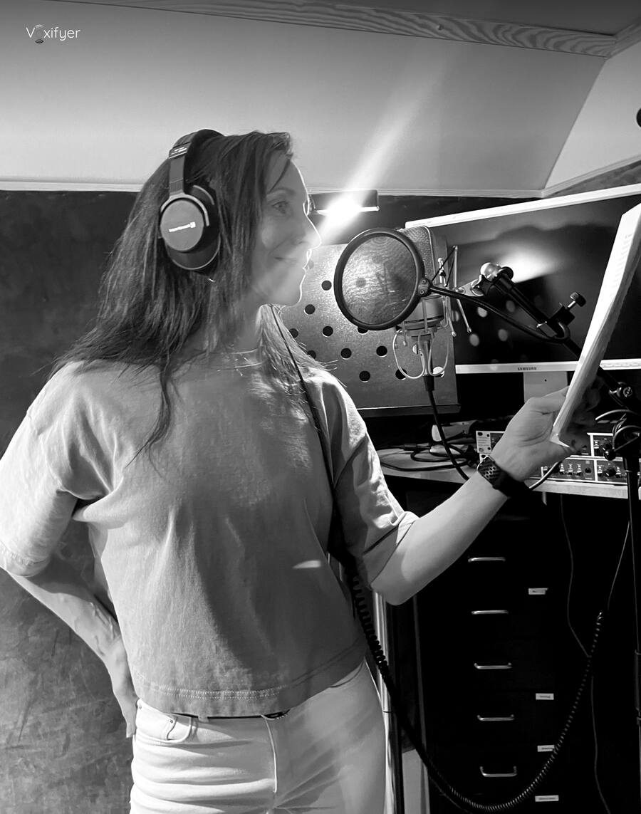 A talent reading a script at the microphone in the Voxifyer booth