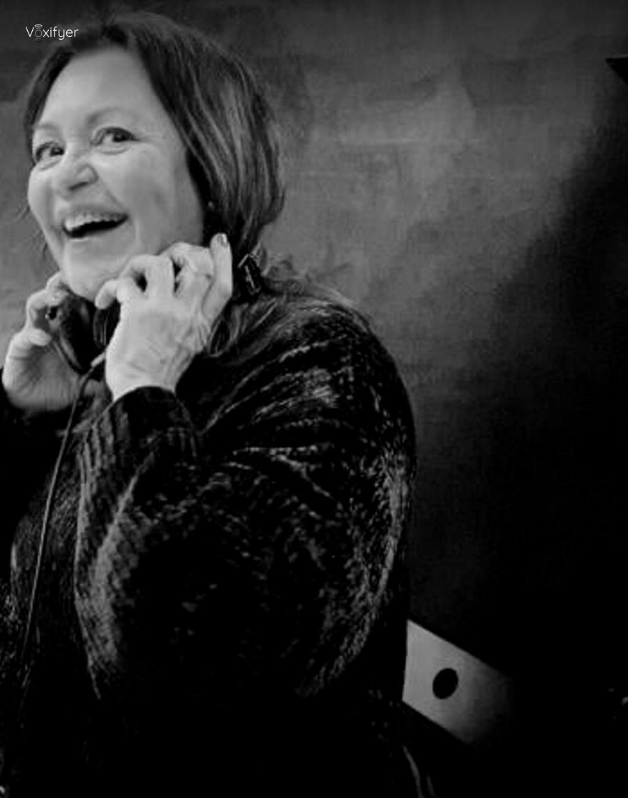 A talent laughing with headphones on during a session